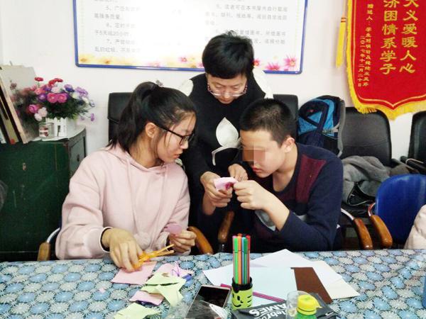 志愿者与孩子一起折纸__.jpg