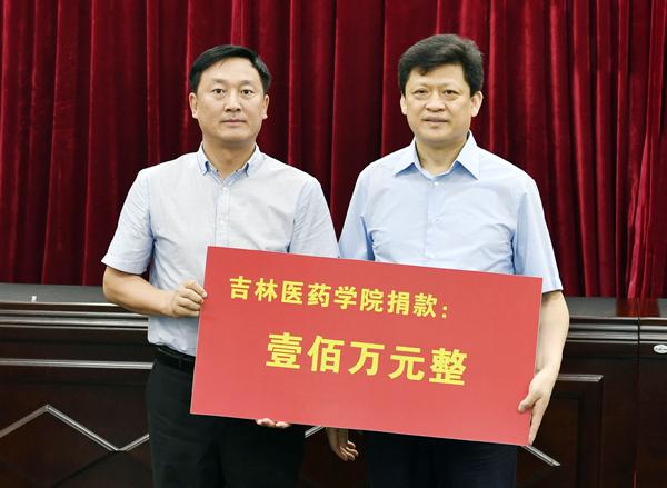 我校副校长林长英（左）将100万元善款交到李天林手中___.jpg
