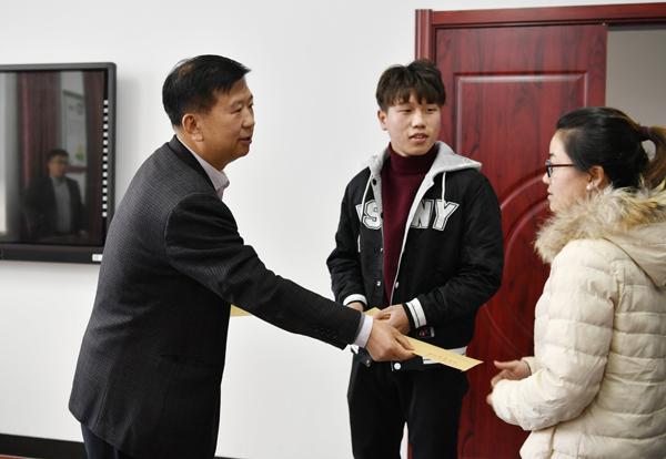 党委书记郑永奎（左）为困难学生发慰问金__.jpg